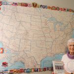 Jan Down stands by map holding a book