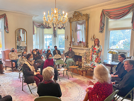 audience seated in parlor for event