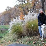 Sandy with her dog by a pond