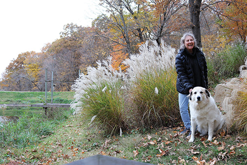 Sandy with her dog by a pond