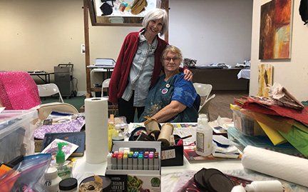 two artists surrounded by collage materials