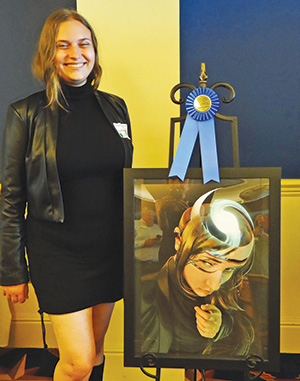 student in front of her art work