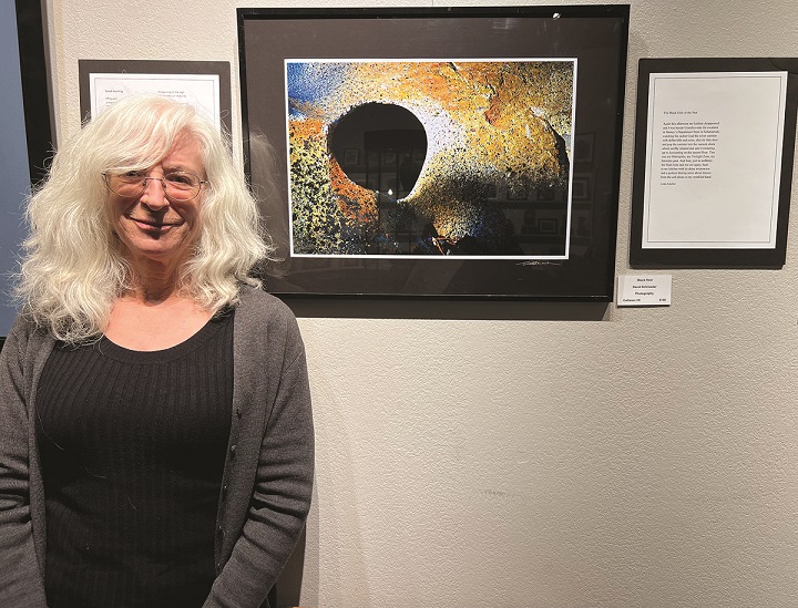 Linda Scheller stands in front of her poem “Black Hole”